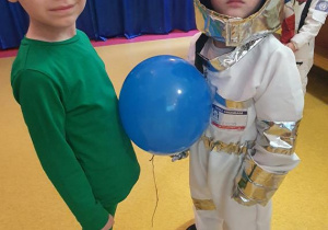 Antek i Jaś tańczą z balonem.